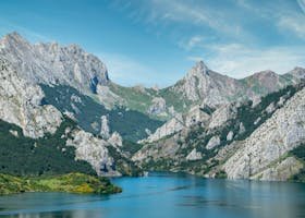 Breathtaking view of a serene mountain lake surrounded by rocky peaks under a clear blue sky.