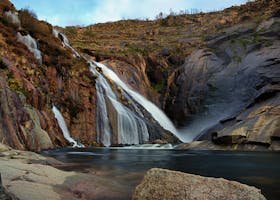Beautiful waterfalls cascade over rocky cliffs in Carnota, Galicia, Spain.