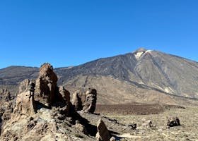 Scenic view of Mount Teide and rugged rock formations under a clear blue sky in Tenerife.